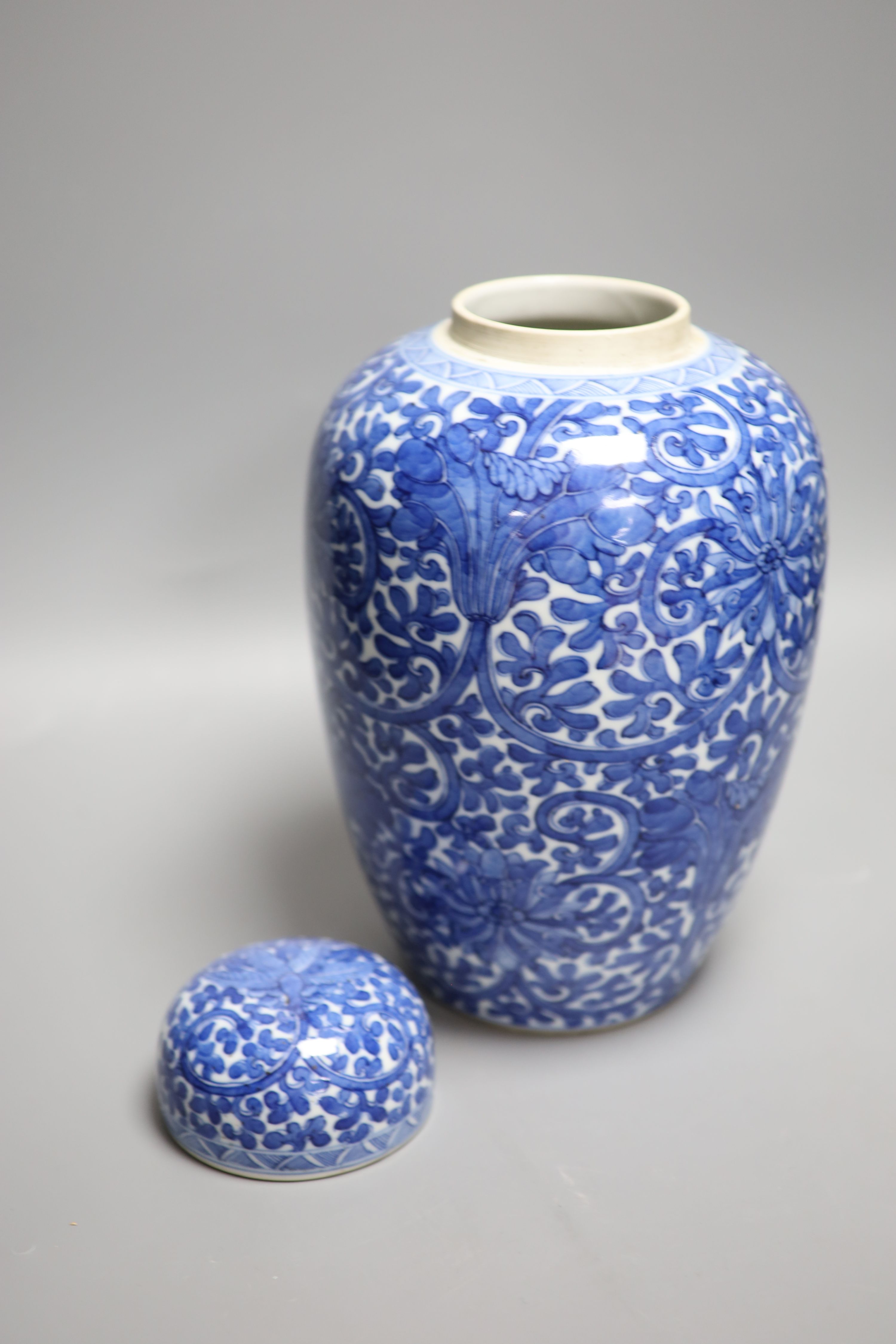 A Chinese blue and white lotus jar and cover, early 20th century, a similar dragon vase and a small Kangxi jarlet and cover, talles